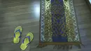 Sepasang sandal ada dekat sajadah di kamar hotel tempat fotografer Associated Press Rafiq Maqbool dikarantina, Mumbai, India, 24 April 2020. Berdoa membantunya merasa lebih baik. (AP Photo/Rafiq Maqbool)