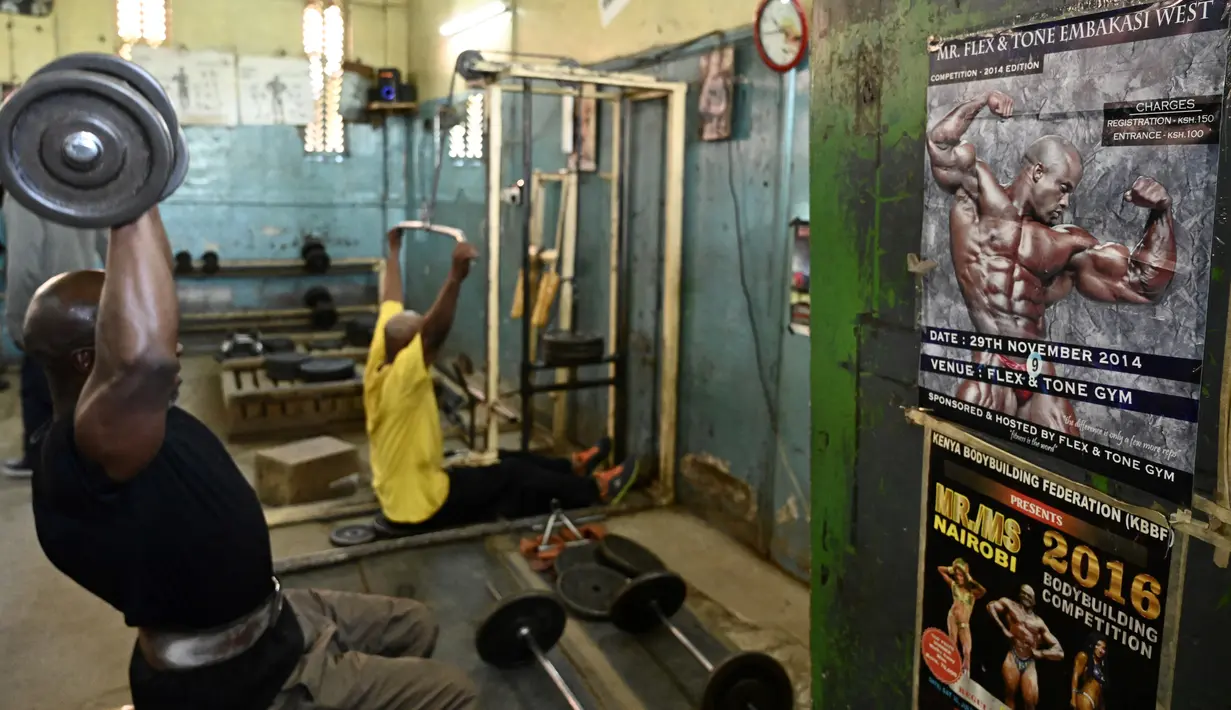Seorang binaragawan mengangkat beban saat berolahraga di gym Kaloleni, di Nairobi, Kenya (9/1). (AFP Photo/Simon Maina)