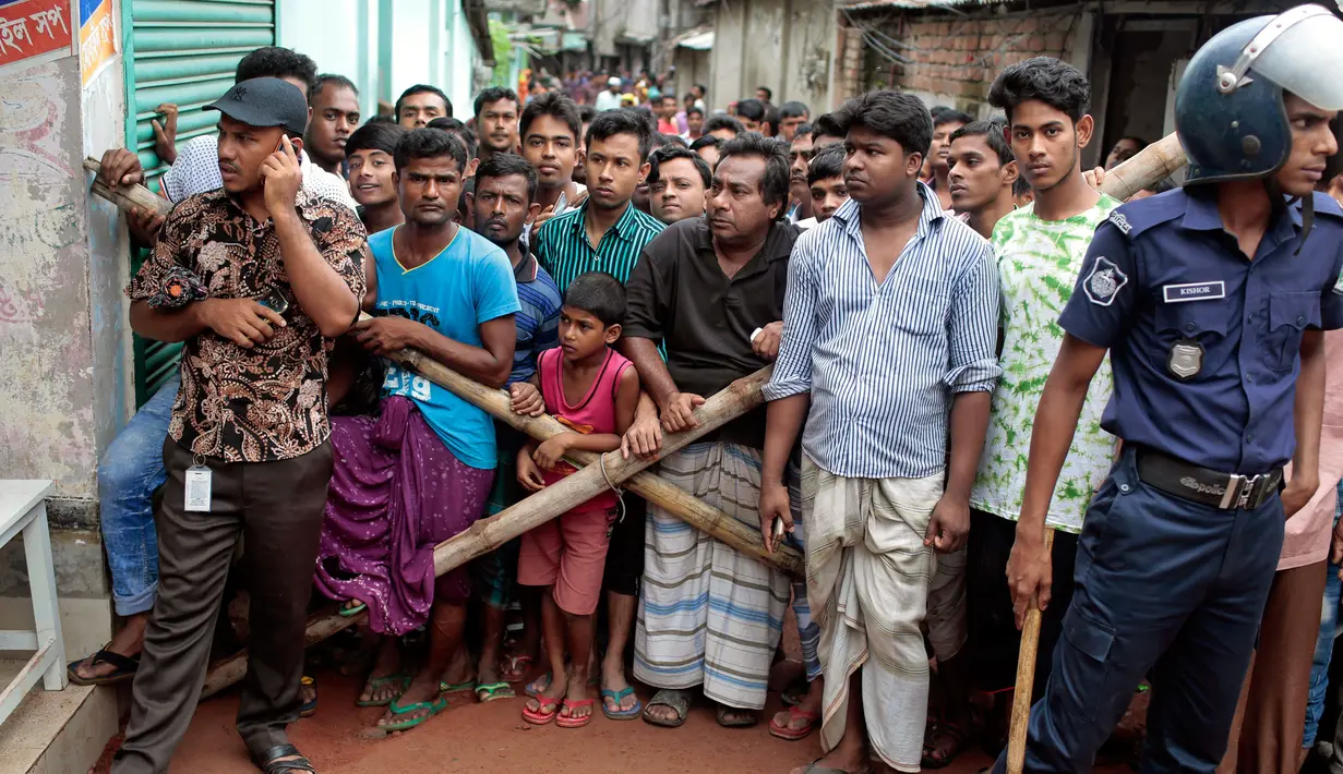 Petugas keamanan memblokade warga agar tidak mendekat ke lokasi ledakan pabrik di Dhaka, Bangladesh (4/7). Perusahaan garmen milik Multifabs Limited tersebut memasok pakaian rajutan yang dijual keluar negri. (AP Photo / AM Ahad)