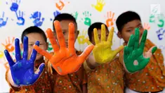 Empat siswa menunjukkan tangan berlumuran cat air di SD Negeri 15 Karet Tengsin, Jakarta, Rabu (18/10). Kegiatan yang diadakan operator penyedia air Palyja digelar dalam rangka Hari Cuci Tangan Pakai Sabun Sedunia. (Liputan6.com/Fery Pradolo)