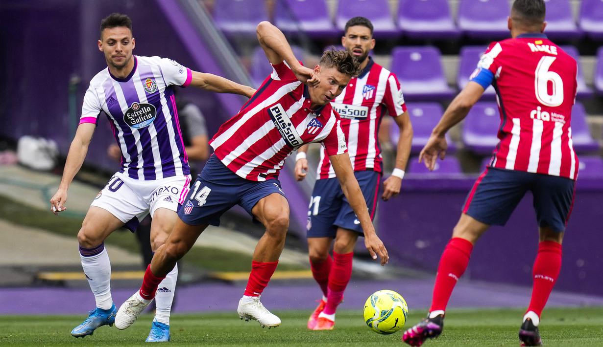 Pemain Atletico Madrid, Marcos Llorente, berebut bola dengan pemain Real Valladolid, Oscar Plano, pada laga Liga Spanyol di Stadion Jose Zorrilla, Sabtu (22/5/2021). Atletico Madrid menang dengan skor 2-1. (AP/Manu Fernandez)