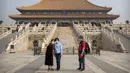 Pengunjung mengenakan masker saat berswafoto di Kota Terlarang, Beijing, China, Jumat (1/5/2020). Kota Terlarang kembali dibuka setelah ditutup lebih dari tiga bulan karena pandemi virus corona COVID-19. (AP Photo/Mark Schiefelbein)