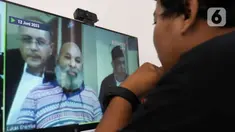 Jurnalis menyaksikan sidang perdana terdakwa kasus pencucian uang, yang juga Gubernur Papua nonaktif Lukas Enembe secara daring di media center Gedung Merah Putih KPK, Jakarta, Senin (12/6/2023). (Liputan6.com/Herman Zakharia)