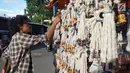 Pedagang merapikan pelita dagangannya yang dijual di Jalan Sam Ratulangi, Kota Gorontalo, Rabu (22/5/2019). Pelita ini terbuat dari botol bekas yang dipasangi sumbu. (Liputan6.com/Arfandi Ibrahim)