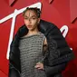 FKA Twigs berpose untuk fotografer setibanya di British Fashion Awards di London, Senin, 5 Desember 2022. Wanita berusia 34 tahun itu menarik perhatian banyak orang dengan penampilannya yang unik, yaitu wajahnya ditutupi bintik-bintik gelap dalam pola melingkar. (AFP/DANIEL LEAL)
