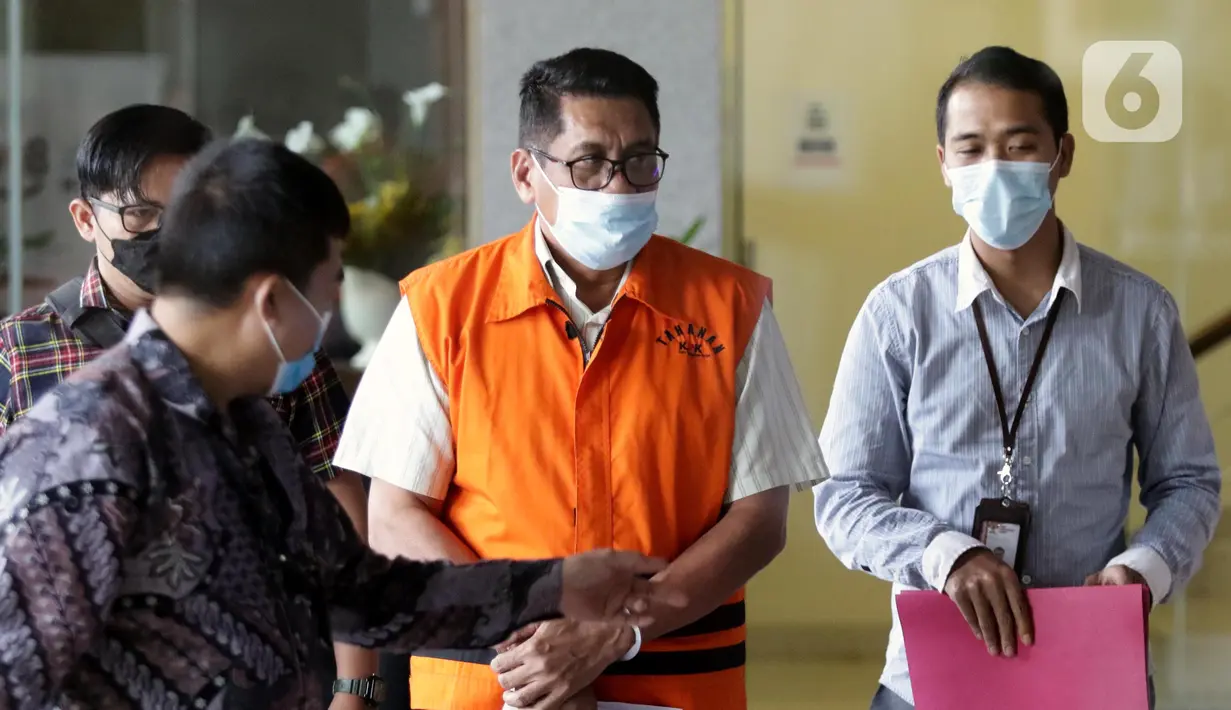 Petugas KPK mengawal Kepala Badan Kepegawaian dan Pengembangan SDM Kabupaten Muna, Sukarman Loke sebelum rilis penahanan tersangka di Gedung KPK, Jakarta, Kamis (23/6/2022). Sukarman Loke resmi mengenakan rompi oranye KPK setelah terjerat kasus korupsi pengajuan dana PEN untuk Kabupaten Kolaka Timur tahun 2021. (Liputan6.com/Helmi Fithriansyah)