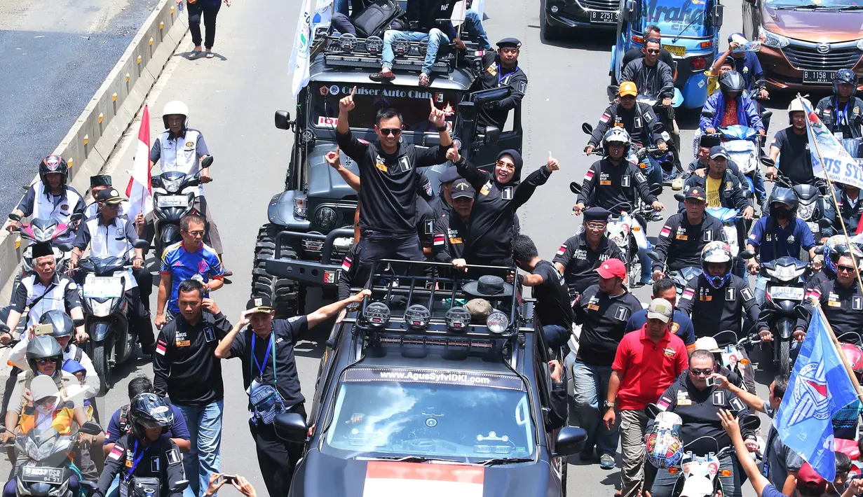 Pasangan Agus H Yudhoyono dan Sylviana Murni menyapa warga saat berada di mobil karnaval di Thamrin, Jakarta, Sabtu (29/10). Karnaval tersebut merupakan bentuk kampanye damai untuk pemilihan Gubernur DKI Jakarta. (Liputan6.com/Angga Yuniar)