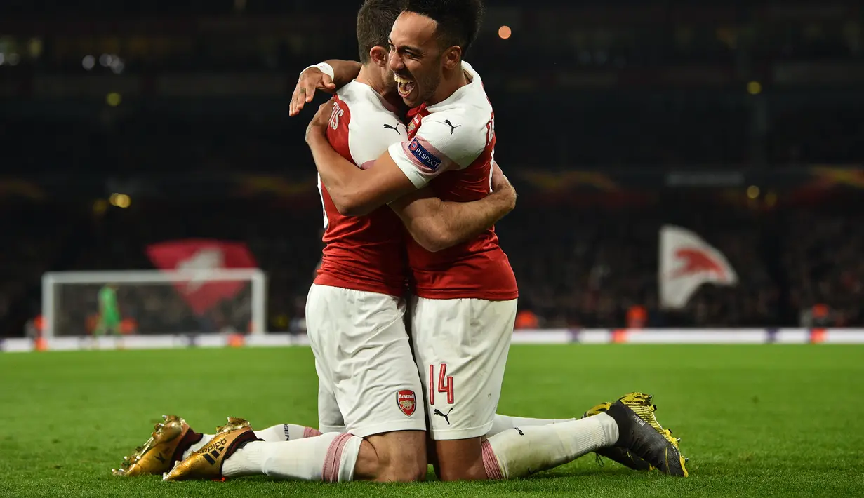 Selebrasi Aubameyang dan Sokratis Papastathopoulus pada leg 2, babak 16 besar Liga Europa yang berlangsung di stadion Emirates, London, Jumat (22/2). Arsenal menang 3-0 atas Bate Borisov. (AFP/Glyn Kirk)