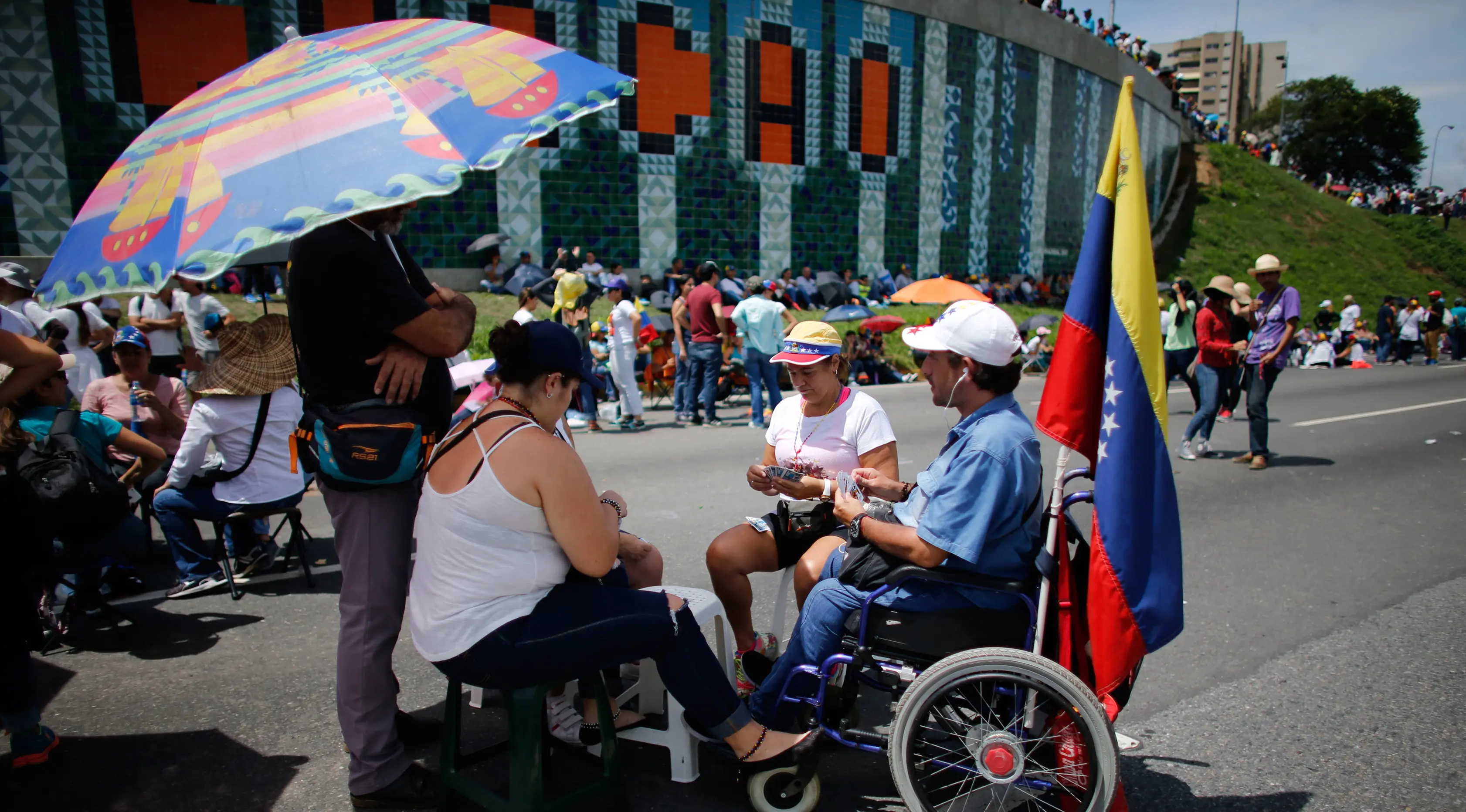 Demonstran anti-pemerintah memainkan kartu di jalan raya saat unjuk rasa melawan Presiden Nicolas Maduro, di Caracas, Venezuela, (15/5). Para demonstran menuntut Presiden Nicolas Maduro mundur dari jabatannya. (AP Photo / Ariana Cubillos)