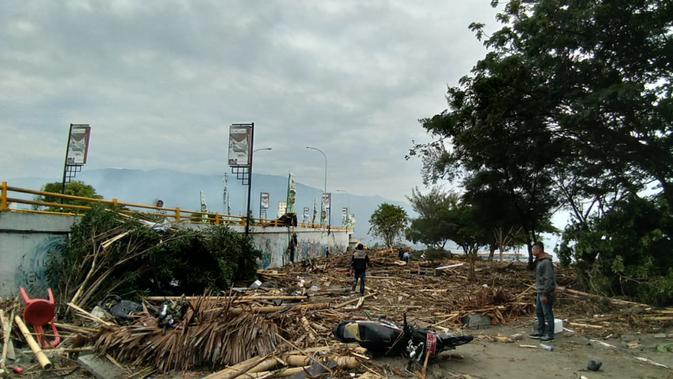 Warga memeriksa kerusakan akibat gempa dan tsunami di Palu, Sulawesi Tengah , Sabtu (29/9). Gelombang tsunami setinggi 1,5 meter yang menerjang Palu terjadi setelah gempa bumi mengguncang Palu dan Donggala. (AFP /OLA GONDRONK)