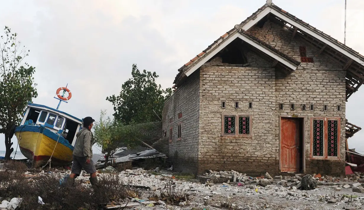 Seorang warga mengecek kondisi rumah yang ditinggalkan di dusun Regahan Lada, Pulau Sebesi, Lampung, Senin (31/12). Banyak warga dusun ini yang bertahan di lokasi pascatsunami yang melanda Selat Sunda pada 22 Desember lalu. (Liputan6.com/Herman Zakharia)