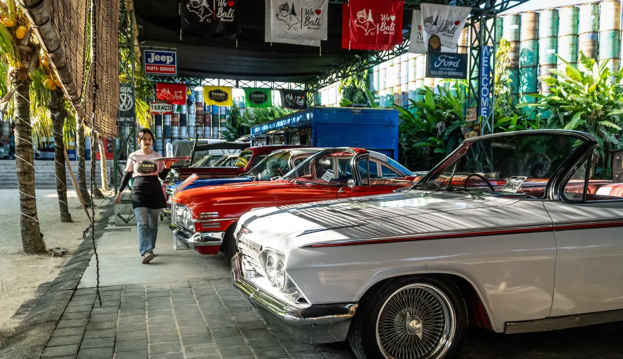 Foto yang diambil pada 14 Oktober 2025 ini menunjukkan Chevrolet Impala (kanan) tahun 1962 di Museum Mobil Antik Kebon, Bali. Jos Dharmawan memiliki koleksi mobil yang mencerminkan Indonesia sebelum dan sesudah penjajahan Belanda berakhir pada akhir Perang Dunia II. (Dicky Bisinglasi/AFP)
