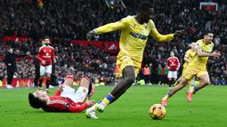 Pemain Manchester United, Lisandro Martinez (kiri) mengeram kesakitan setelah berebut bola dengan pemain Crystal Palace, Ismaila Sarr (kanan) dalam laga lanjutan Liga Inggris 2024/2025 di Old Trafford, Manchester, Inggris, Minggu (02/02/2025). (AFP/Paul Ellis)