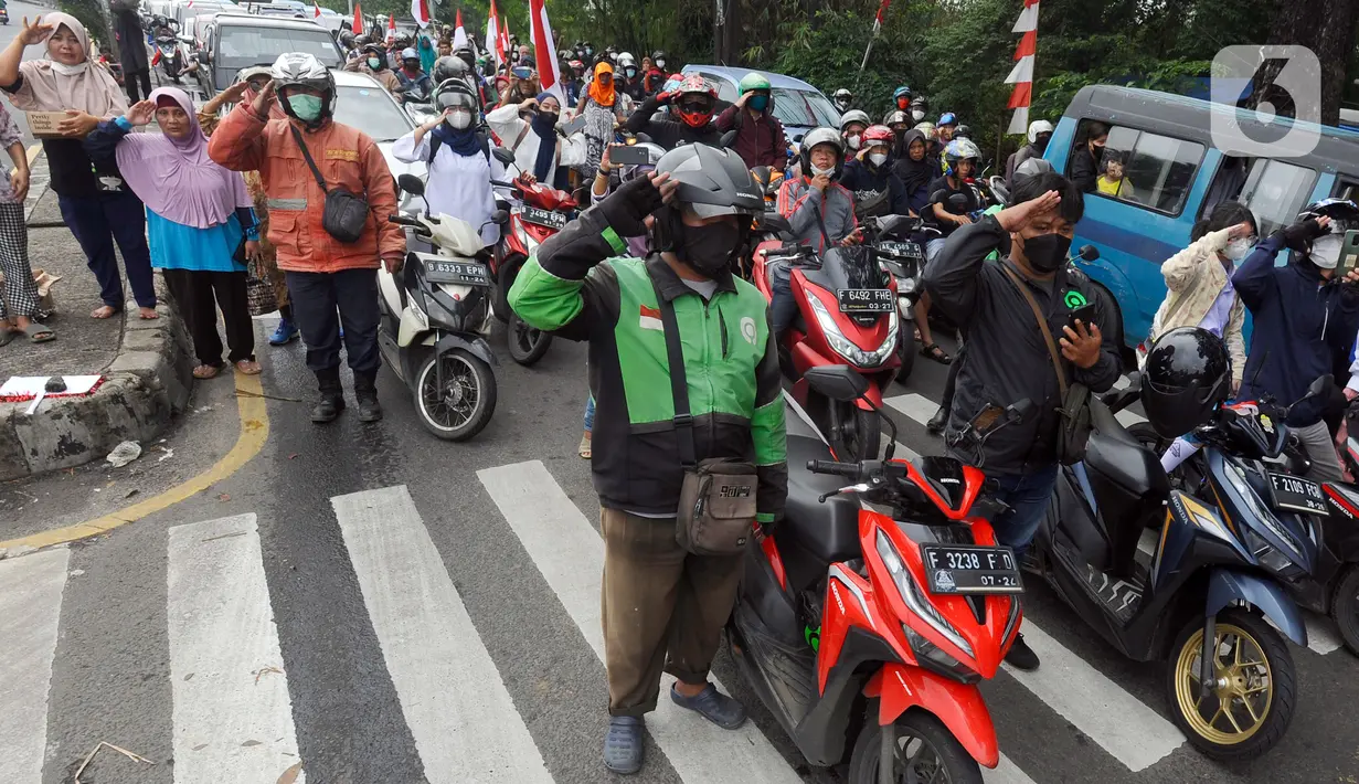 Pengguna jalan melakukan penghormatan saat detik-detik proklamasi 17 Agustus di ruas jalan protokol Jakarta-Bogor, pertigaan Cibinong, Bogor, Jawa Barat, Rabu (17/8/2022). Sejumlah pengguna jalan terlihat turun dari kendaraannya dan melakukan sikap hormat. (merdeka.com/Arie Basuki)