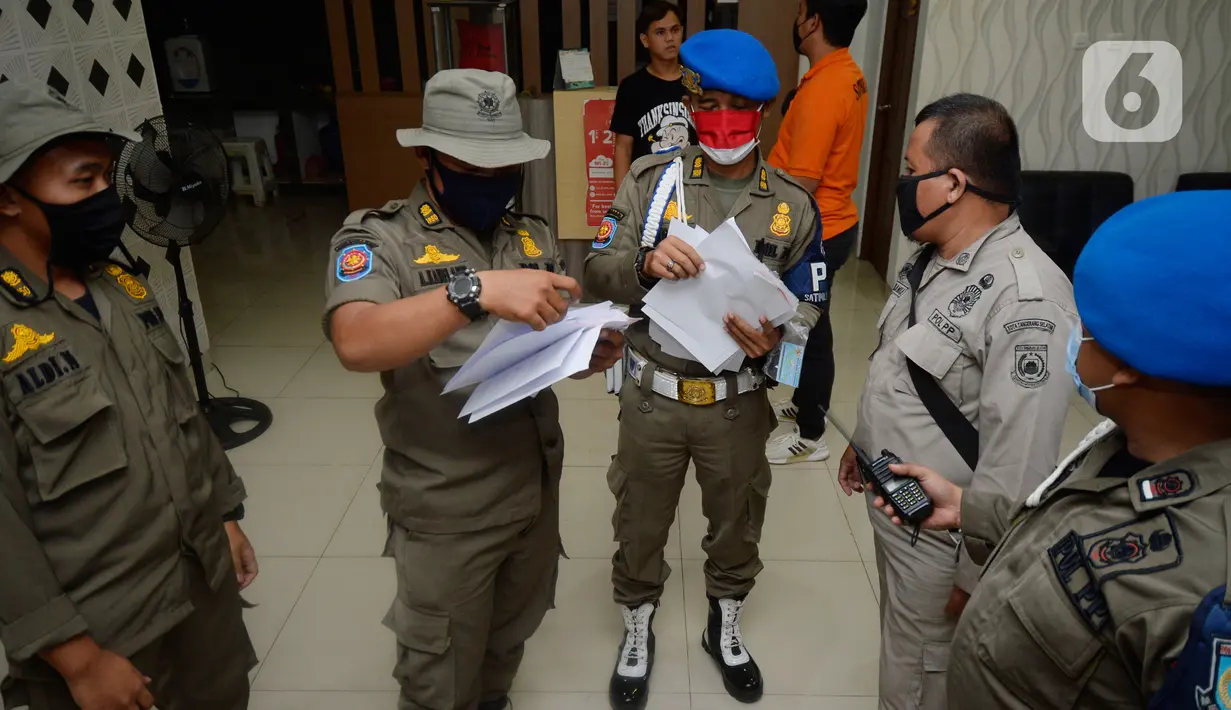 Satpol PP Tangerang Selatan melakukan pendataan terhadap para tamu yang menginap di Hotel Reddoorz, BSD, Serpong, Jumat (21/08/2020). Satpol PP mengamankan sejumlah pasangan bukan suami istri dalam sebuah operasi di hotel-hotel ketika Pemkot Tangsel memperpanjang PSBB. (merdeka.com/Dwi Narwoko)