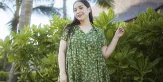 Nagita Slavina tampil elegan mengenakan dress panjang warna hijau army dengan motif bunga-bunga warna kuning. Credit: Instagram (@raffinagita1717)