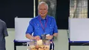 Perdana Menteri Malaysia, Najib Razak memasukkan surat suara ke kotak saat pemilihan umum (Pemilu) di TPS wilayah Pekan, Pahang, Rabu (9/5). Pemilu ini pertarungan antara PM Najib yang sudah berkuasa sejak 2009, melawan Mahathir Mohamad. (AP/Aaron Favila)