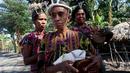 Sejumlah wanita memainkan alat musik tradisional dalam upacara peresmian bantuan bedah rumah di Desa Oebelo, NTT, Selasa (14/8). Upacara penyambutan diwarnai dengan tarian-tarian menggunakan alat musik baba khas daerah itu. (Liputan6.com/Johan Tallo)