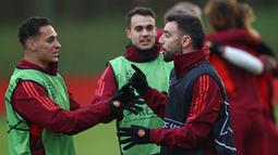 Pemain MU, Anthony (kiri) bercengkrama dengan Bruno Fernandes, dalam sesi latihan yang berlangsung di Carrington, Manchester, Selasa (12/12/2023) dini hari WIB. (AFP/Darren Staples)