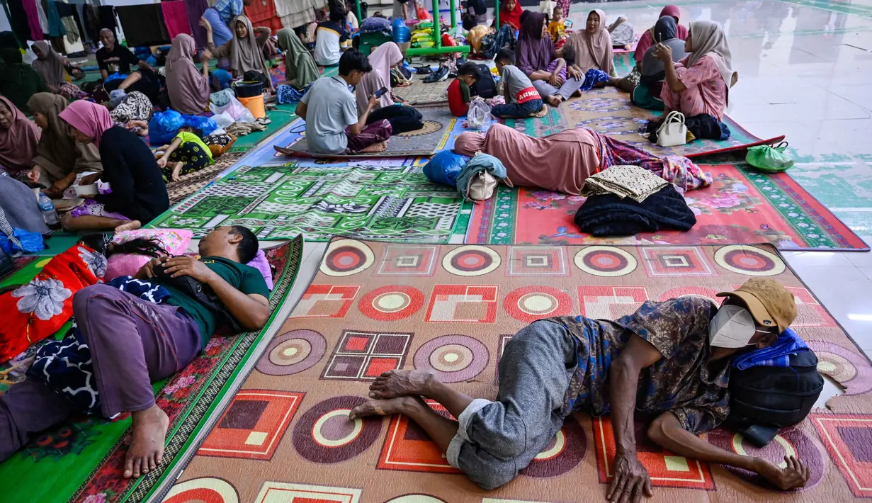 BPBD Pidie Jaya juga mencatat ada sekitar 1.247 rumah terendam, dan 67 lainnya rusak berat akibat longsor. Tampak dalam foto, warga desa terdampak banjir beristirahat di tempat pengungsian setelah banjir bandang melanda Meureudu, Kabupaten Pidie Jaya, Provinsi Aceh, pada 29 November 2025. (CHAIDEER MAHYUDDIN/AFP)