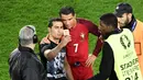 Seorang penggemar masuk lapangan dan mengajak berfoto Cristiano Ronaldo seusai laga Portugal melawan Austria pada laga kedua Grup F Piala Eropa 2016di Parc des Princes, Minggu (19/6/2016) dini hari WIB. (AFP/Miguel Medina)