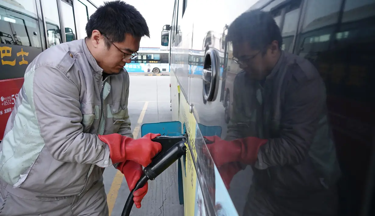 Seorang staf mengisi daya bus listrik di Wilayah Laixi, Provinsi Shandong, China, 14 Januari 2020. Untuk mengurangi emisi karbon dan melestarikan lingkungan, Wilayah Laixi telah mengonversi seluruh bus umum yang dimilikinya menjadi 116 bus listrik di area perkotaan sejauh ini. (Xinhua/Ding Hongfa)