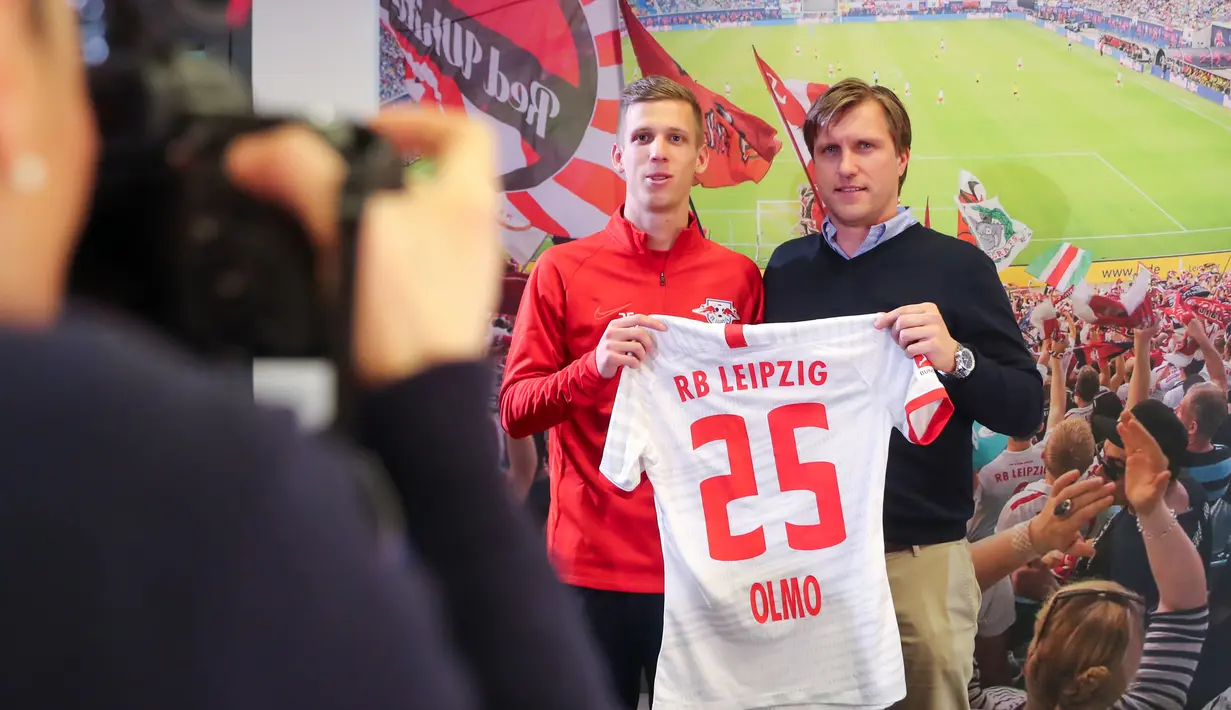 Gelandang baru RB Leipzig asal Spanyol, Dani Olmo bersama direktur olahraga Markus Kroesche berpose dengan jersey klub barunya di Leipzig, Jerman timur (27/1/2020). Dani Olmo bakal bermain di Red Bull Arena selama 4,5 tahun ke depan. (Jan Woitas/dpa/AFP)