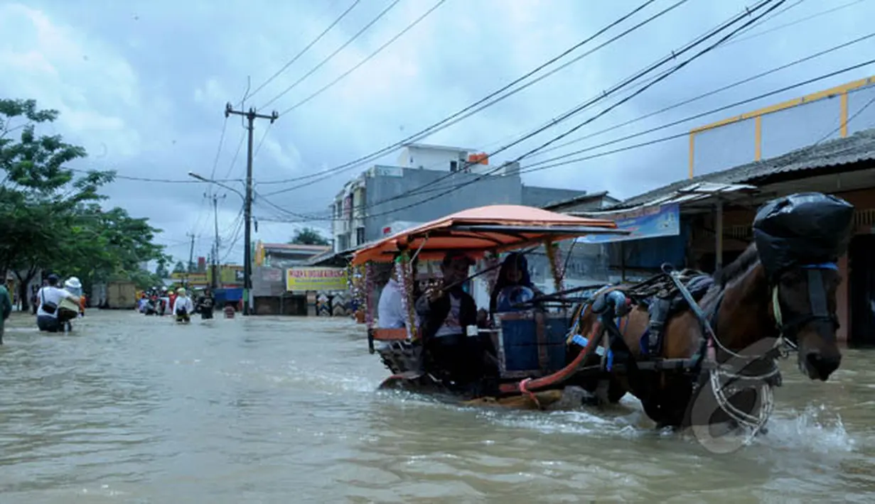 Delman menjadi alat transportasi pilihan warga saat banjir melanda kawasan Jalan KH Hasyim Ashari, Ciledug, Kota Tangerang, Selasa (10/2/2015). (Liputan6.com/Andrian M Tunay)