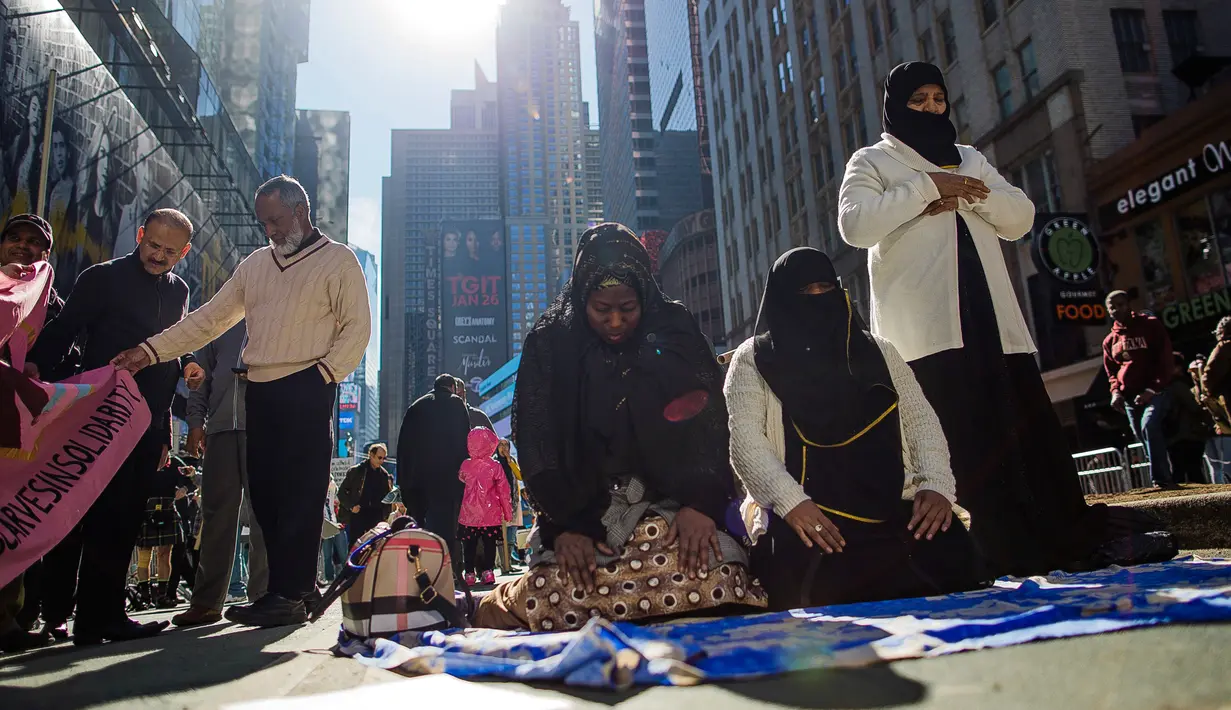 Sejumlah perempuan Muslim menunaikan salat dalam unjuk rasa mendukung Muslim Amerika dan aksi protes kebijakan imigrasi Presiden Donald Trump di Times Square, New York, Minggu (19/2). (AP/Andres Kudacki)