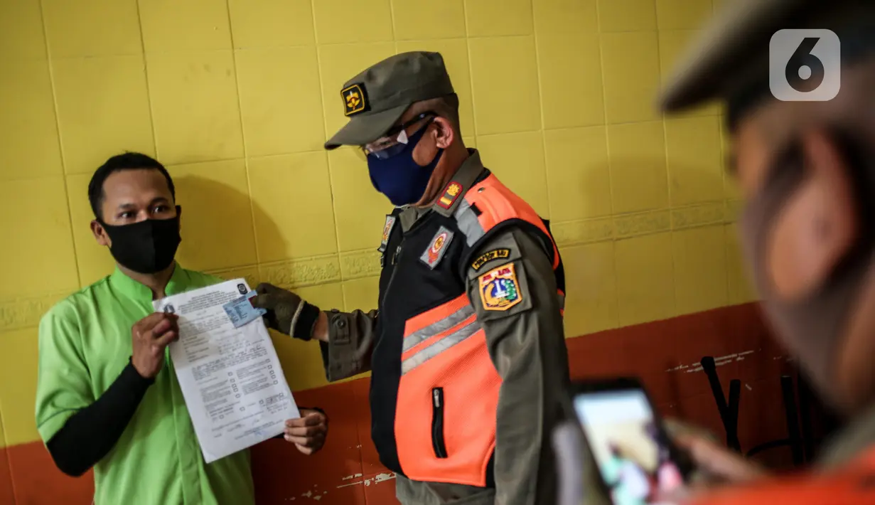Petugas Satpol PP menertibkan warung makan yang melanggar aturan pembatasan sosial berskala besar (PSBB) di kebon kacang, Jakarta, Senin (1/6/2020). Pelanggaran berupa menerima pelanggan yang makan di warung ditertibkan oleh petugas untuk mencegah penyebaran COVID-19. (Liputan6.com/Faizal Fanani)