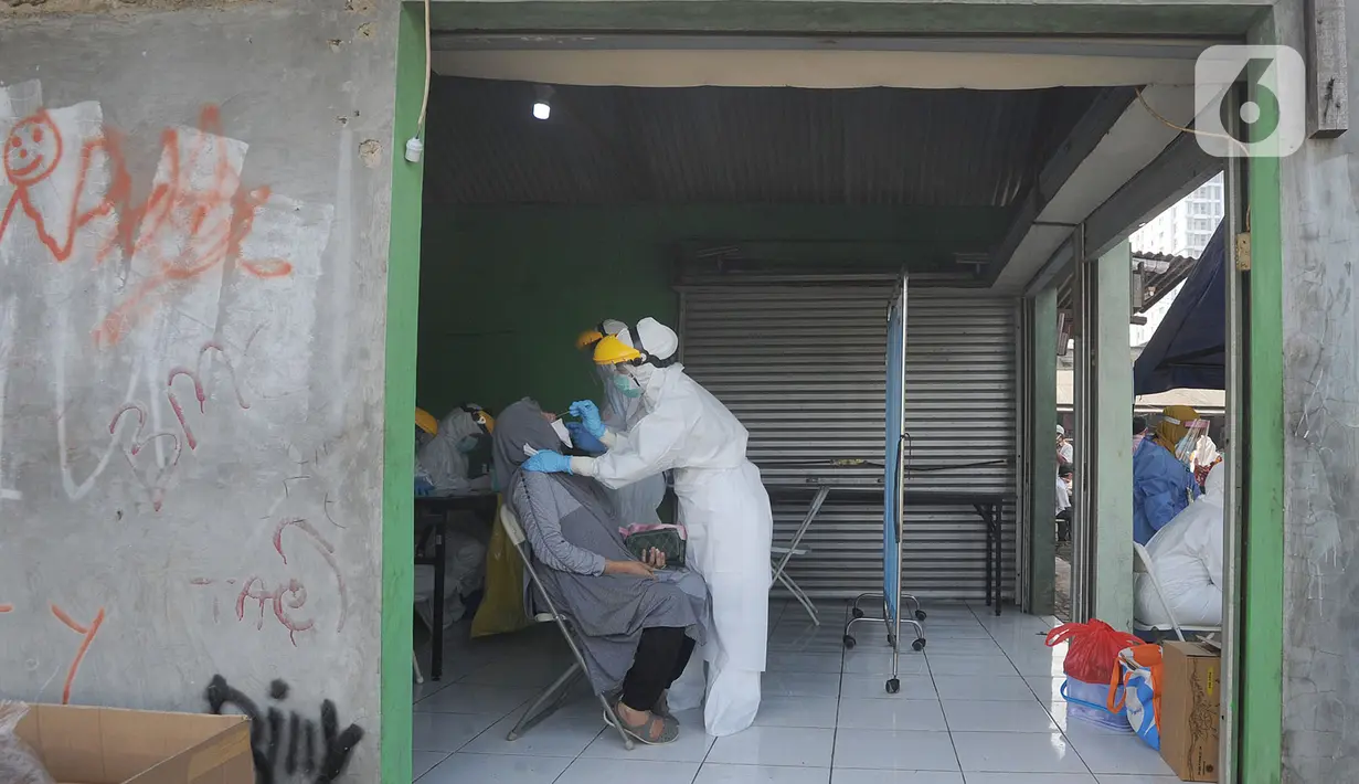 Petugas medis dari Pemkot Jakarta Selatan melakukan tes swab Covid-19 para pedagang  di Pasar Sayur Cipulir, Jakarta Selatan, Kamis (25/6/2020). Kegiatan yang dilakukan kepada puluhan pedagang dan warga seputar pasar ini dalam rangka memutus mata rantai penyebaran Covid-19. (merdeka.com/Arie Basuki)