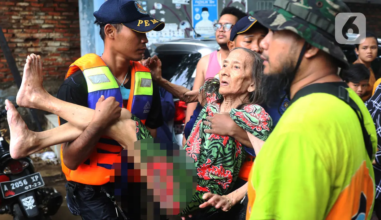 Petugas membantu mengevakuasi warga yang terjebak banjir di perumahan Ciledug Indah, Tangerang, Rabu (1/1/2020). Banjir setinggi dada orang dewasa terjadi akibat meluapnya kali angke. (Liputan6.com/Angga Yuniar)
