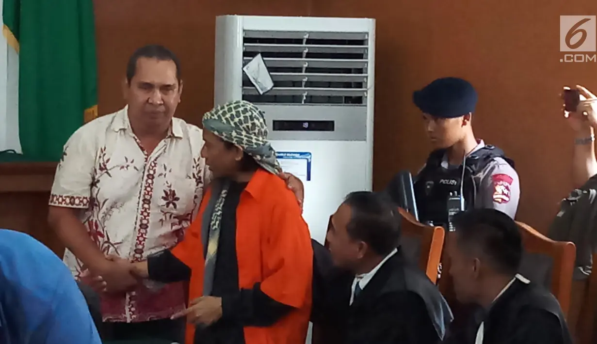 Korban ledakan bom di Jalan MH Thamrin pada Januari 2016, Ipda Denny Mahieu menyalami terdakwa Aman Abdurrahman di PN Jakarta Selatan, Jumat (23/2). Dalam sidang, Denny menceritakan kembali peristiwa dua tahun lalu itu. (Liputan6.com/Ady Anugrahadi)