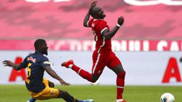 Pemain Liverpool, Sadio Mane, terjatuh saat berebut bola dengan pemain RB Salzburg, Jerome Onguene, pada laga persahabatan di Stadion Red Bull Arena, Salzburg, Selasa (25/8/2020). Kedua tim bermain imbang dengan skor 2-2. (AP Photo/Matthias Schrader)