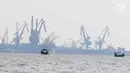 Nelayan berlayar saat aktivitas bongkar muat barang ekspor impor di Pelabuhan Tanjung Priok, Jakarta, Senin (17/7). Badan Pusat Statistik melaporkan kinerja ekspor dan impor Indonesia mengalami susut signifikan di Juni 2017. (Liputan6.com/Angga Yuniar)