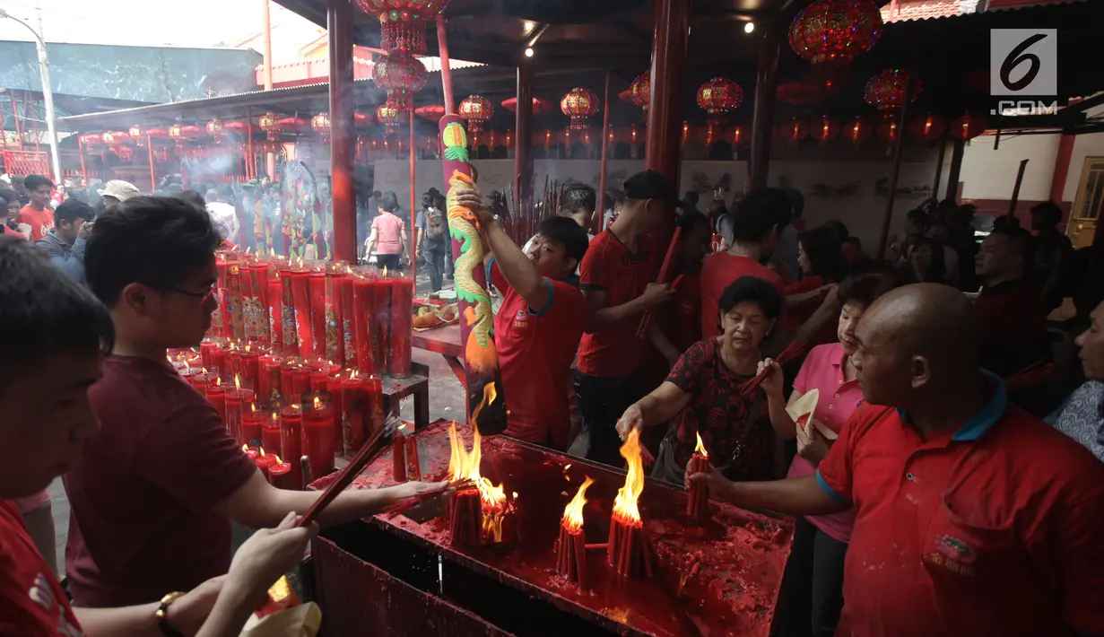 Warga keturunan Tionghoa membakar dupa saat sembahyang Imlek 2569 di Vihara Dharma Bhakti, Petak Sembilan, Jakarta Barat, Jumat (16/2). Selain membakar dupa dan memanjatkan doa, mereka juga saling bercengkrama satu sama lain. (Liputan6.com/Arya Manggala)