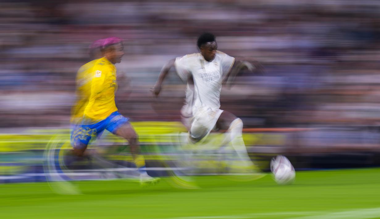 Penyerang Real Madrid Vinicius Junior (kanan) berlari dengan bola di samping bek Las Palmas Julian Araujo dalam laga pekan ke-7 La Liga 2023/2024, Kamis (28/9/2023). (AP Photo/Manu Fernandez)
