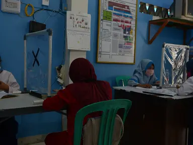 Pelajar saat kegiatan pembelajaran Jarak Jauh (PJJ) dengan memanfaatkan Jak Wifi di Balai Warga RW 02 Kelurahan Galur, Jakarta, Jumat (4/9/2020). Program internet gratis dari Pemprov DKI itu untuk pelajar di permukiman padat penduduk yang kesulitan mengakses internet. (merdeka.com/Imam Buhori)
