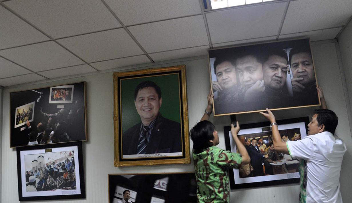 Seorang staf tampak membantu Ahmad Yani mencopot sebuah bingkai foto di ruang kerjanya di gedung Parlemen, Jakarta, (11/9/14). (Liputan6.com/Miftahul Hayat)