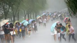 Sejumlah warga Taiwan berjalan melawan angin kencang saat badai Topan Soudelor mulai mendekati di Hangzhou, Zhejiang, Taiwan (7/8/2015). Ratusan warga dievakuasi karena topan terkuat dalam dua tahun terakhir mengancam wilayah tersebut.  (REUTERS/Stringer)