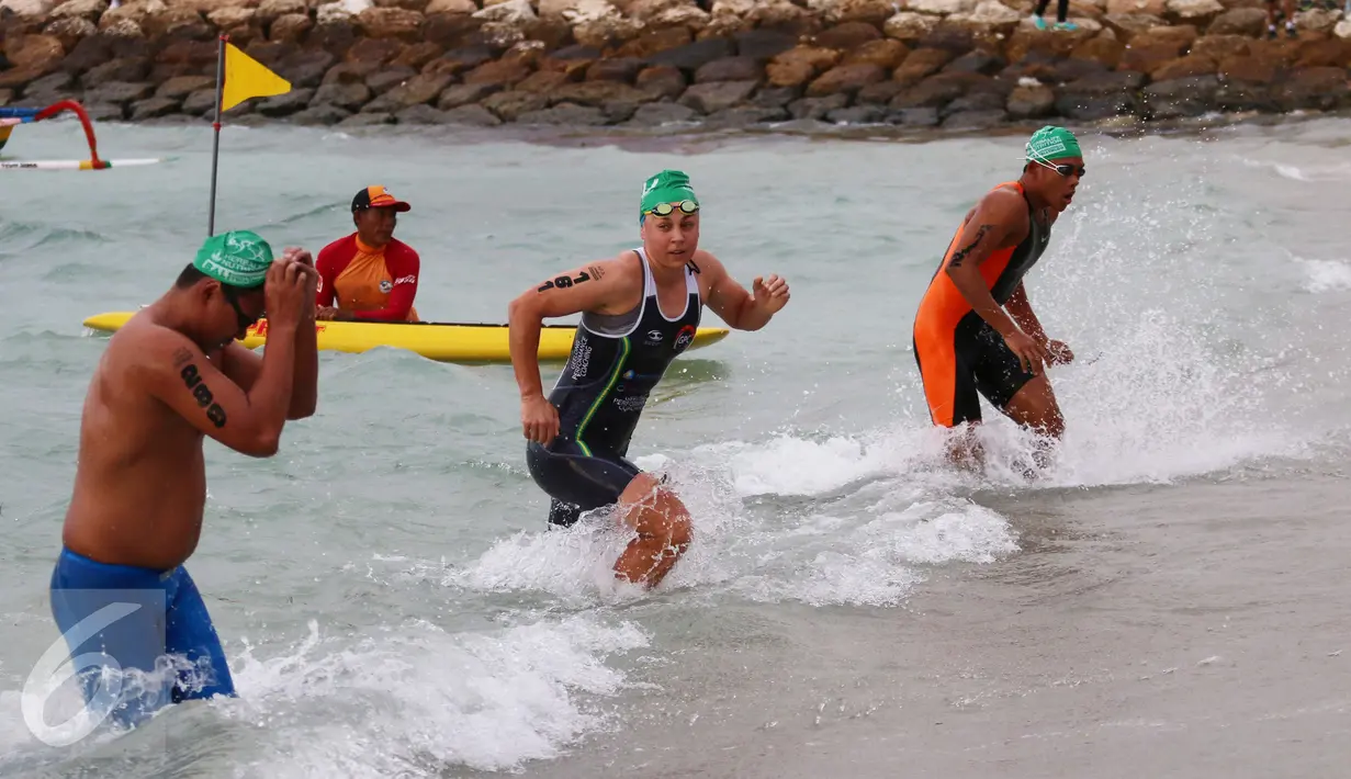 Peserta tiba di pantai usai berenang sepanjang 1,5 km pada Herbalife Bali International Triathlon 2016 di Sanur, Bali, Minggu (14/8). (Liputan6.com/Made Anto)