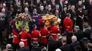 Peti mati Ratu Elizabeth II dibawa dalam Westminster Abbey saat prosesi pemakamannya, London, Inggris, Senin (19/9/2022). Ratu Elizabeth II akan dimakamkan di Windsor bersama mendiang suaminya, Pangeran Philip, yang meninggal tahun lalu. (Phil Noble/Pool Photo via AP)
