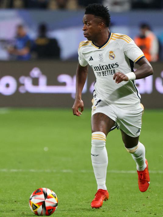 Pemain Real Madrid, Vinicius Junior menggiring bola saat laga final Piala Super Spanyol melawan Barcelona di Stadion King Saud University, Riyadh, Arab Saudi Senin (15/1/2024) dini hari WIB. (AFP/Giuseppe Cacace)