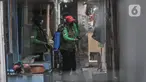 Satgas Covid-19 menyemprotkan disinfektan sebelum berlangsungnya pembongkaran makam di Buaran, Jakarta Timur, Senin (24/5/2021). Jenazah Trio yang meninggal sehari setelah disuntik vaksin AstraZeneca akan menjalani autopsi di RSCM guna memastikan penyebab kematiannya. (merdeka.com/Iqbal S. Nugroho)