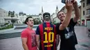 Dua pria berswafoto bersama seorang penggemar sepak bola dengan tato rambut pemain timnas Argentina, Lionel Messi di Serbia, 10 Juni 2018. Hal unik tersebut dalam rangka merayakan gelaran Piala Dunia 2018. (AFP/VLADIMIR ZIVOJINOVIC)