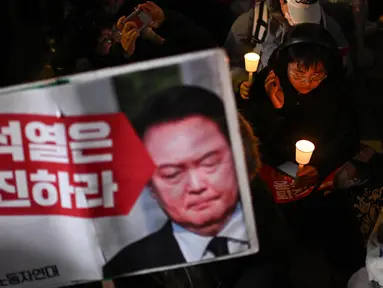 Orang-orang mengambil bagian dalam acara menyalakan lilin untuk menyerukan pengunduran diri Presiden Korea Selatan Yoon Suk Yeol di Seoul pada tanggal 4 Desember 2024. (Philip FONG/AFP)