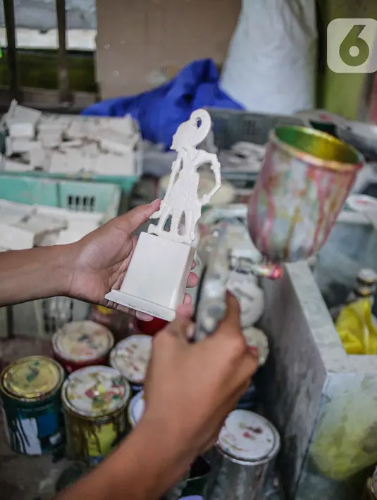 Pekerja mengecat plakat yang sedang dibuat di Industri Rumahan Pluit, Penjaringan, Jakarta Utara, Rabu (30/10/2019). Plakat yang terbuat dari bahan baku resin plastik tersebut didistribusikan di kawasan Ibu Kota. (Liputan6.com/Faizal Fanani)