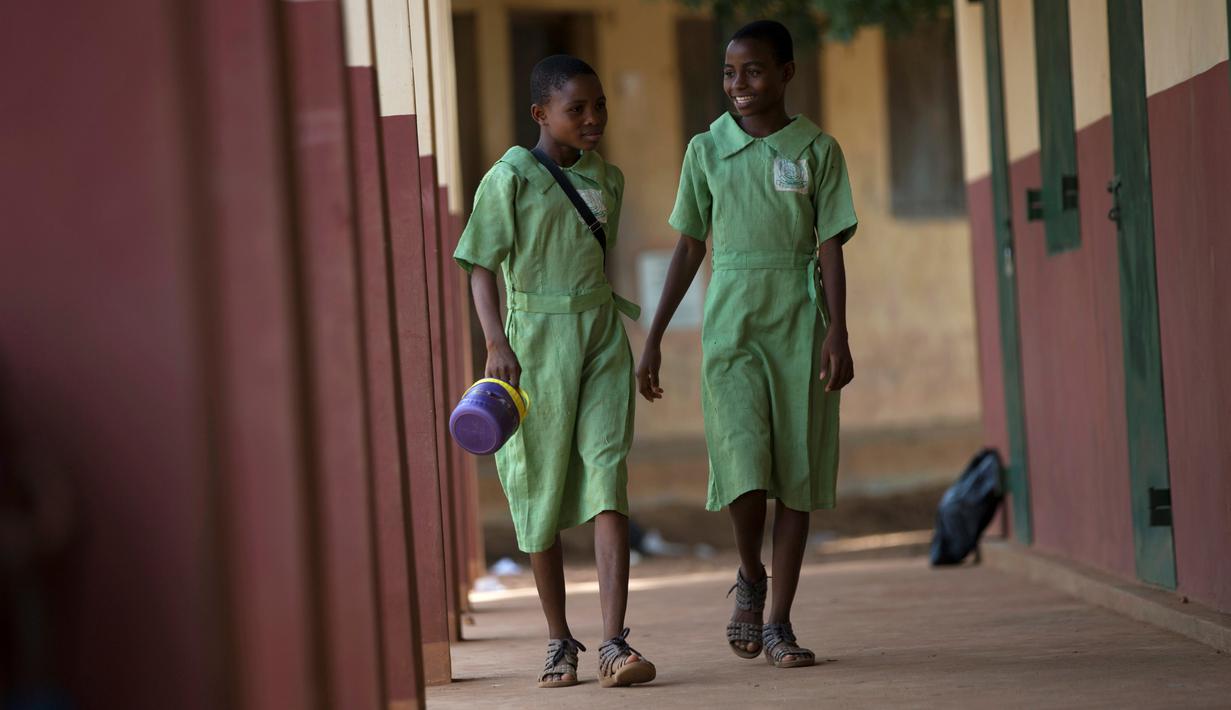 Kembar tidak identik, Taiwo Oyedepo dan Kehinde Oyedepo berjalan di koridor sekolah mereka di kota Igbo Ora, Nigeria pada 3 April 2019. Igbo Ora, sebuah wilayah di bagian barat daya Nigeria ini terkenal dengan anak-anaknya yang terlahir kembar. (REUTERS/Afolabi Sotunde)
