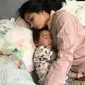 Salah satu pose tidur Nagita Slavina. Nagita nyenyak memeluk Rafathar. (Instagram @raffinagita1717)