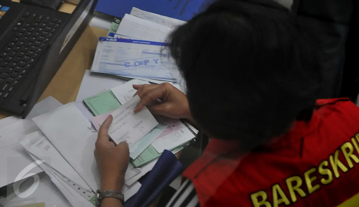 Petugas Bareskrim Polri memeriksa berkas di PT Tirtamarta Wisesa Abadi, Jakarta, Selasa (23/6/2015). Penggeledahan ini terkait kasus dugaan korupsi pengadaan printer dan scanner untuk SMAN dan SMKN di Jakarta. (Liputan6.com/Johan Tallo) 